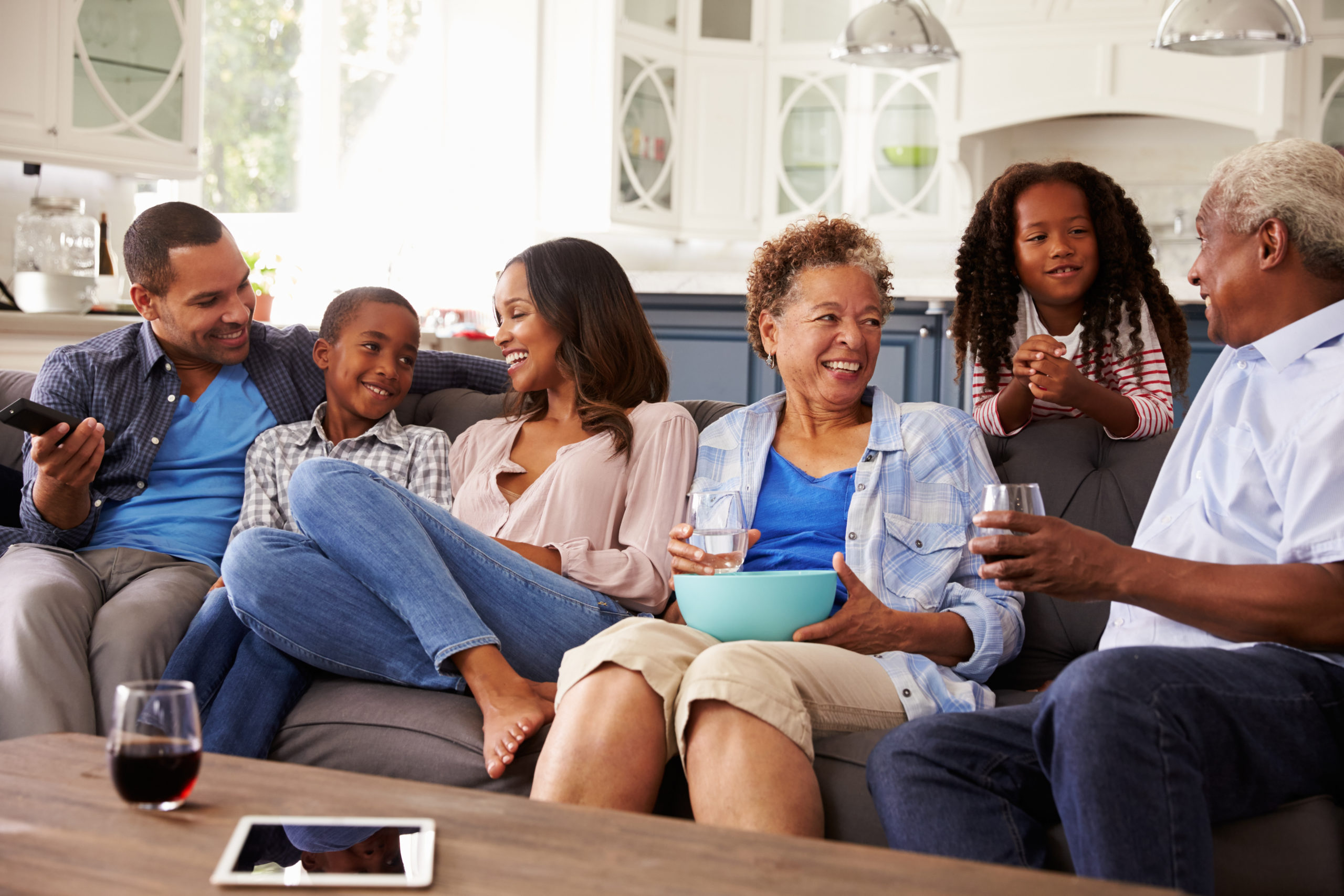 Multi generation black family talking together while watching TV