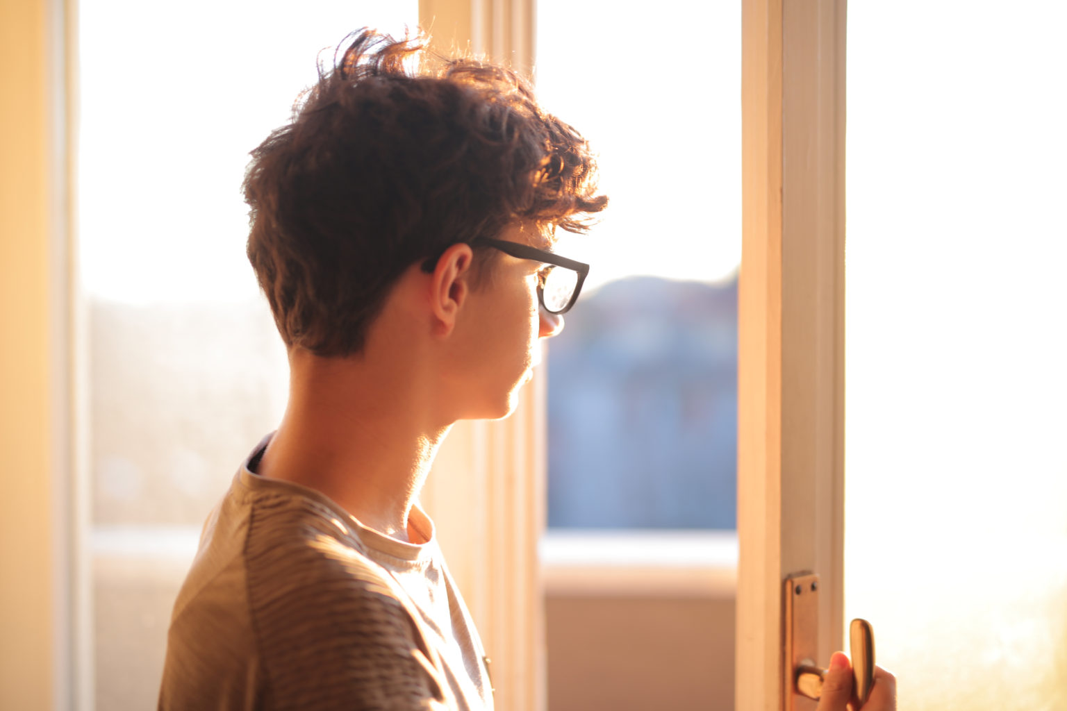 young boy opens a window