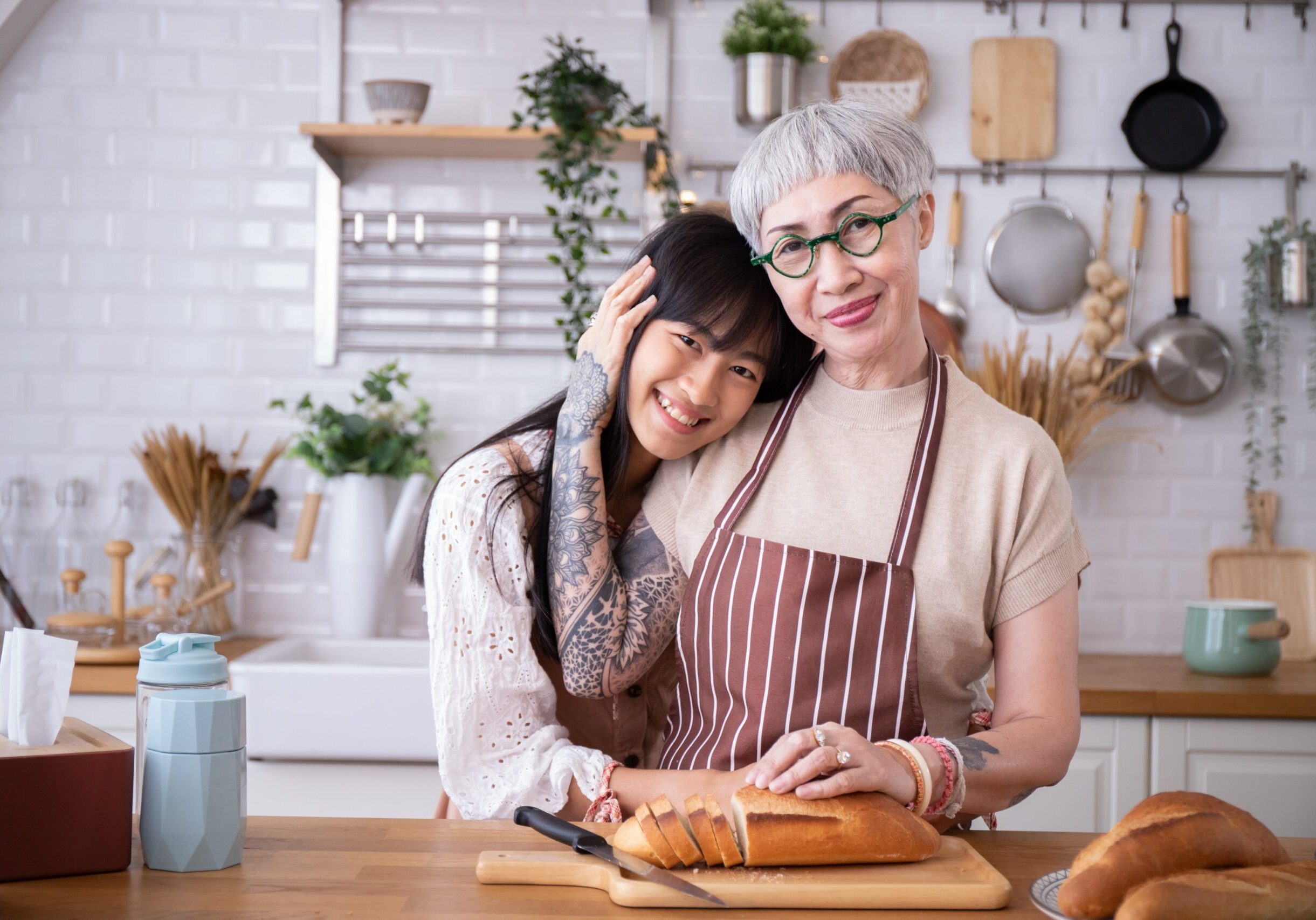 Mother and daughter hugging each other in kitchen.Cook bread bef