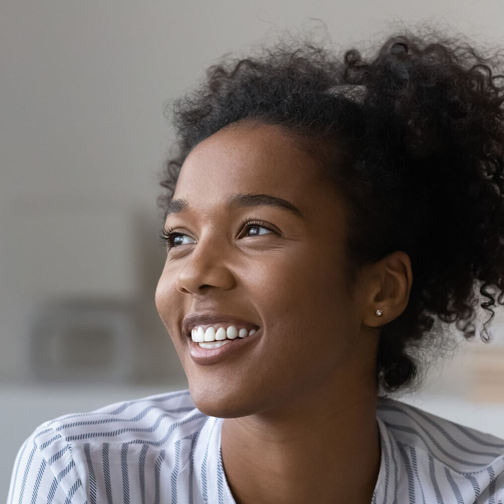 Smiling biracial woman look in distance dreaming Smiling biracial woman look in distance dreaming